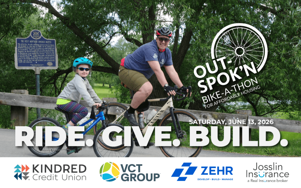 an adult and a child cycling together on a path beside a wooden railing and leafy trees. Both wear helmets and sunglasses, smiling as they ride. Overlaid text reads “Out Spok’n Bike-a-thon for Affordable Housing” with the date “Saturday, June 13, 2026” and the slogan “Ride. Give. Build.” Sponsor logos for Kindred Credit Union, VCT Group, Zehr Group and Josslin Insurance appear along the bottom.